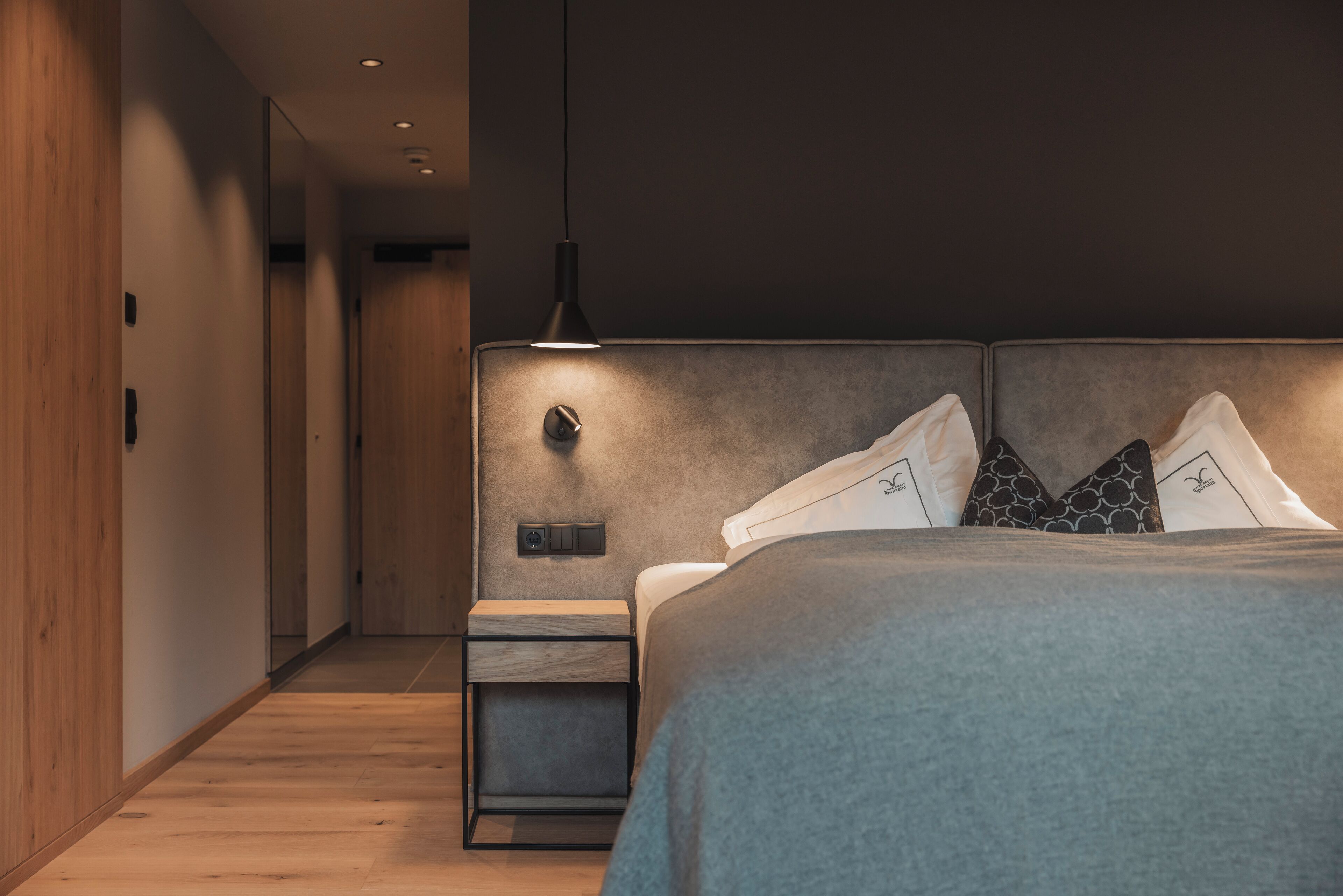 A modern bedroom with a bed, bedside table, and a nightstand.