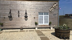 A building with a wooden exterior, a white window, and decorative metal elements. - Le Bois Gautier (Savigny-le-Vieux)