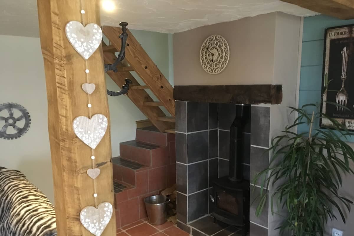 A staircase with wooden railings and heart-shaped decorations, a fireplace, and a potted plant.
