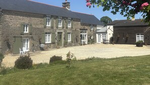 A stone building with multiple windows and a gravel courtyard. - Le Bois Gautier (Savigny-le-Vieux)