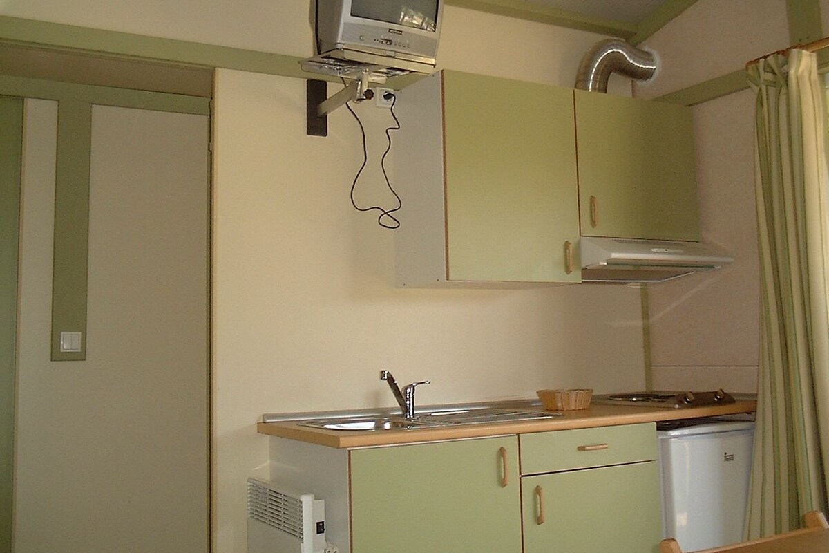 A compact kitchen with a built-in microwave, a sink, and a small countertop.
