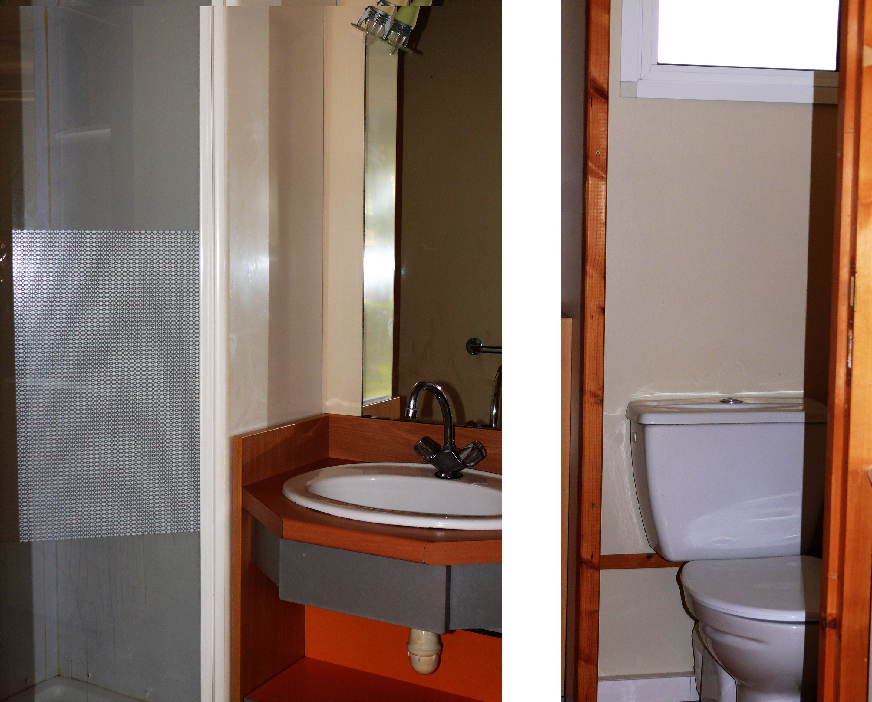 Un baño con lavamanos blanco, espejo y retrete blanco.