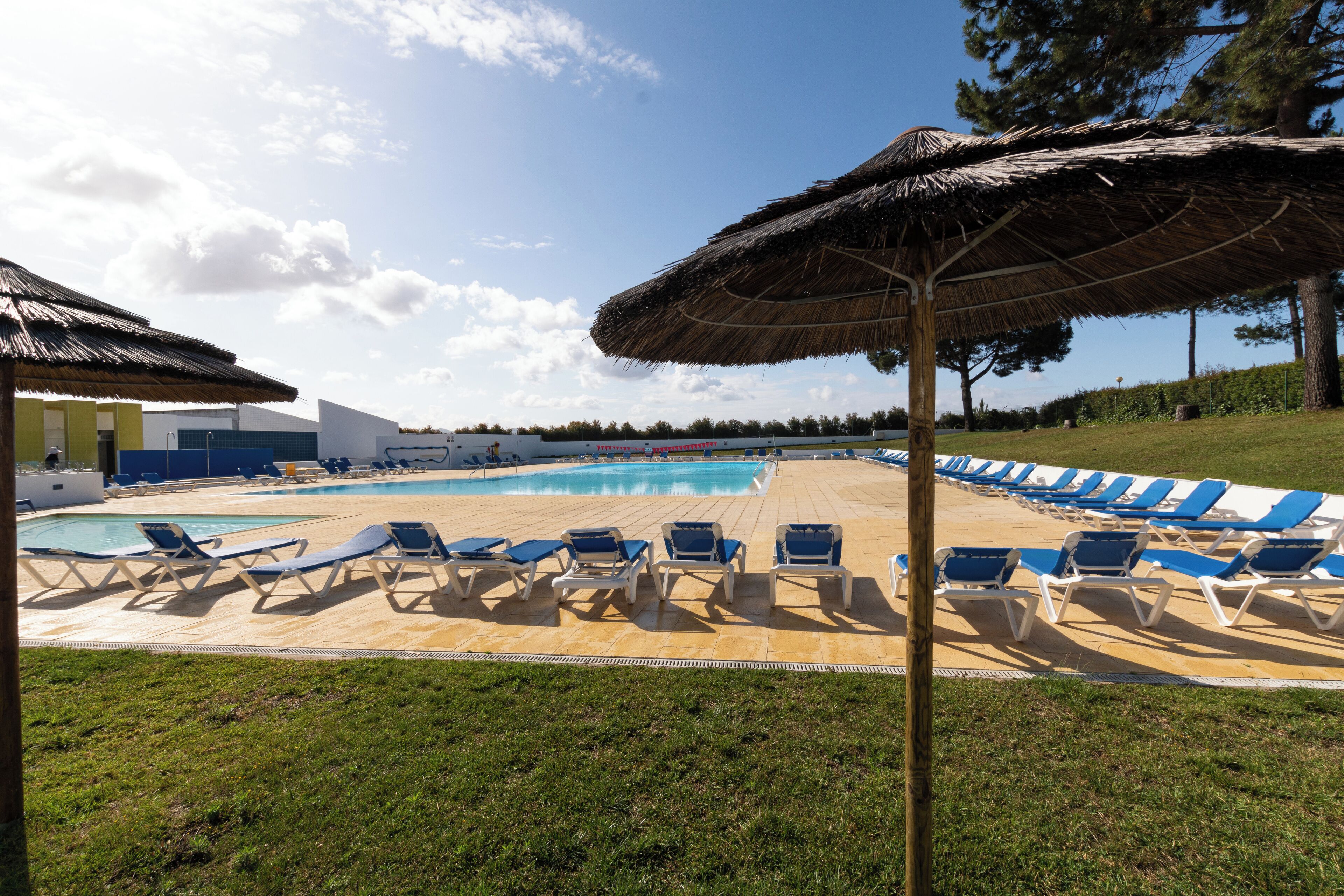 Ein Poolbereich mit Liegestühlen und Sonnenschirmen.