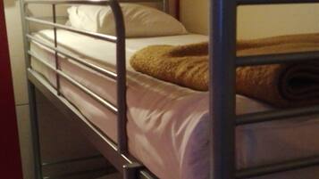 A bunk bed room with metal railings and a wooden floor.