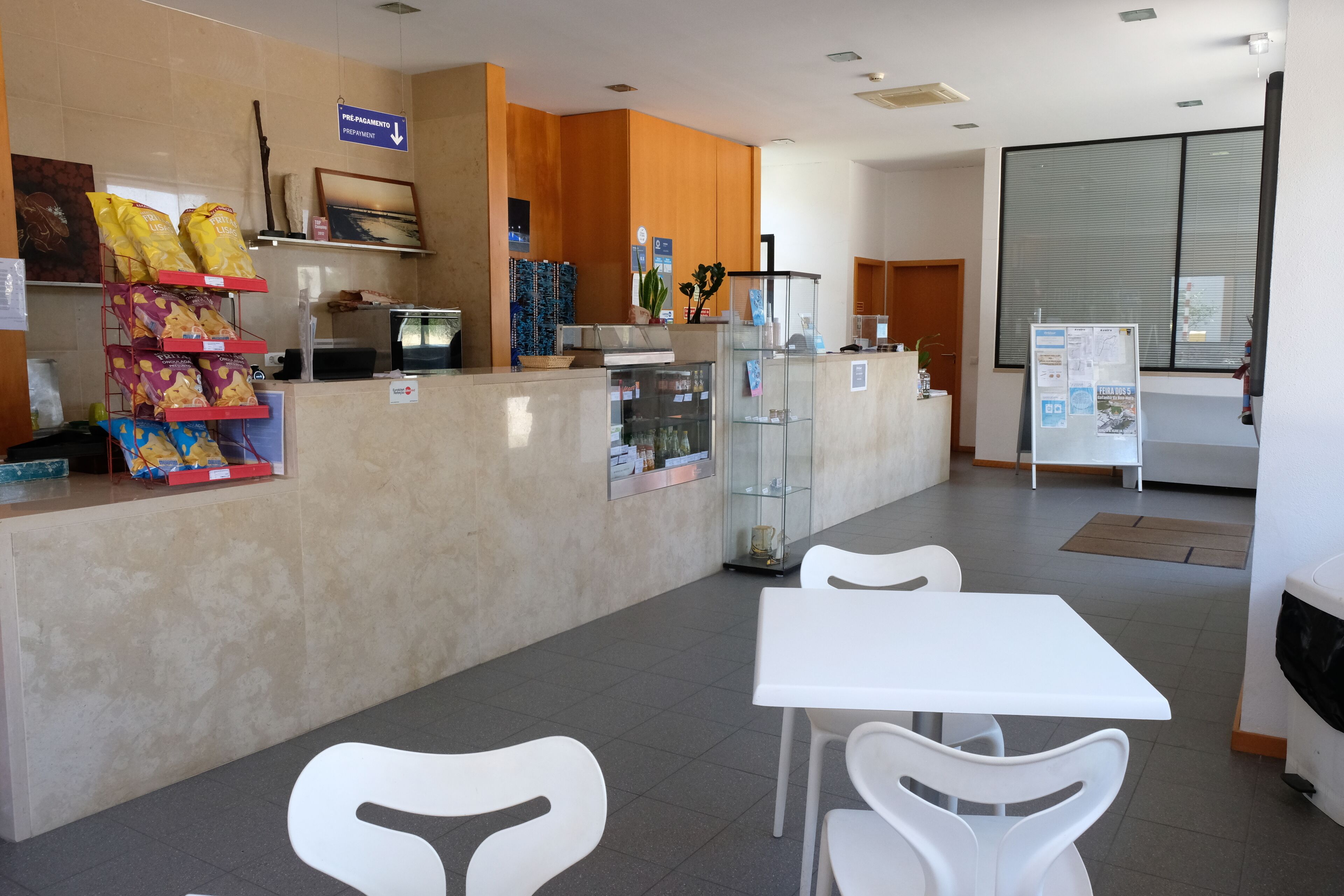 A reception area with a counter, seating, and a refrigerator.