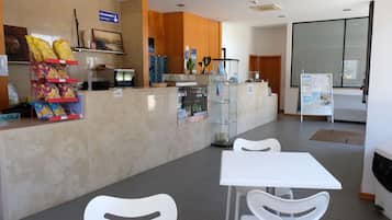 A reception area with a counter, seating, and a refrigerator.