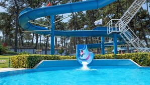 A water park with a large blue water slide and a pool. - Parque de Campismo Orbitur Sao Pedro De Moel (Marinha Grande)
