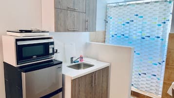 Economy studio suite | Privékitchenette | Een koelkast met diepvriezer, een microgolfoven, een kookplaat