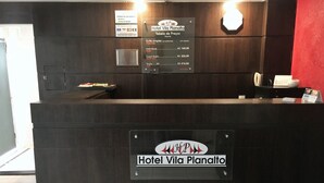 A hotel reception desk with a sign for Hotel Vila Planalto.