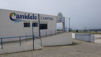 A building with a "Canidelo CAMPING" sign and a logo above the entrance.