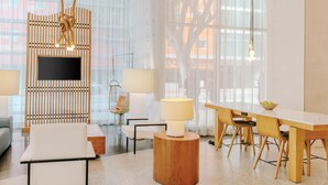 Un salon moderne avec un téléviseur, une table ronde en bois et un canapé.
