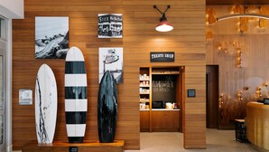 Un mur en bois orné de planches de surf, une enseigne indiquant « MAGASIN DE CONFISERIE » et une autre qui dit « Bienvenue à Santa Monica ».