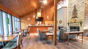 A cozy interior with wooden ceilings, a stone fireplace, and a bar area. - Barren River Lake State Resort Park (Lucas)