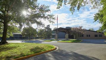 Guests can park their vehicles in a well-maintained area surrounded by mature trees.