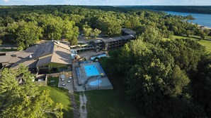 An aerial view of a resort with a swimming pool, multiple buildings, and a lake in the background. - Barren River Lake State Resort Park (Lucas)