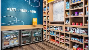 A snack kiosk with refrigerated display cases labeled 'SNACKS TO GO' and 'CHILL OUT.' - Hampton Inn Chicago North-Loyola Station (Chicago)