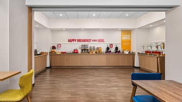 Un área de desayuno con mostrador, asientos y un letrero que dice 'HAPPY BREAKFAST STARTS HERE'.