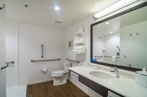 Een moderne badkamer met toilet, bidet, wastafel en spiegel.