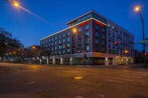 A modern hotel with a prominent 'Hampton Inn' sign, a corner location with a street view, and a crosswalk in front. - Hampton Inn Chicago North-Loyola Station (Chicago)