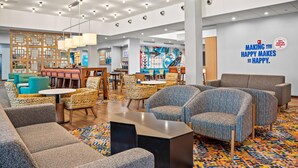 A modern hotel lobby with seating areas, a dining section, and a wall with a motivational quote. - Hampton Inn Chicago North-Loyola Station (Chicago)