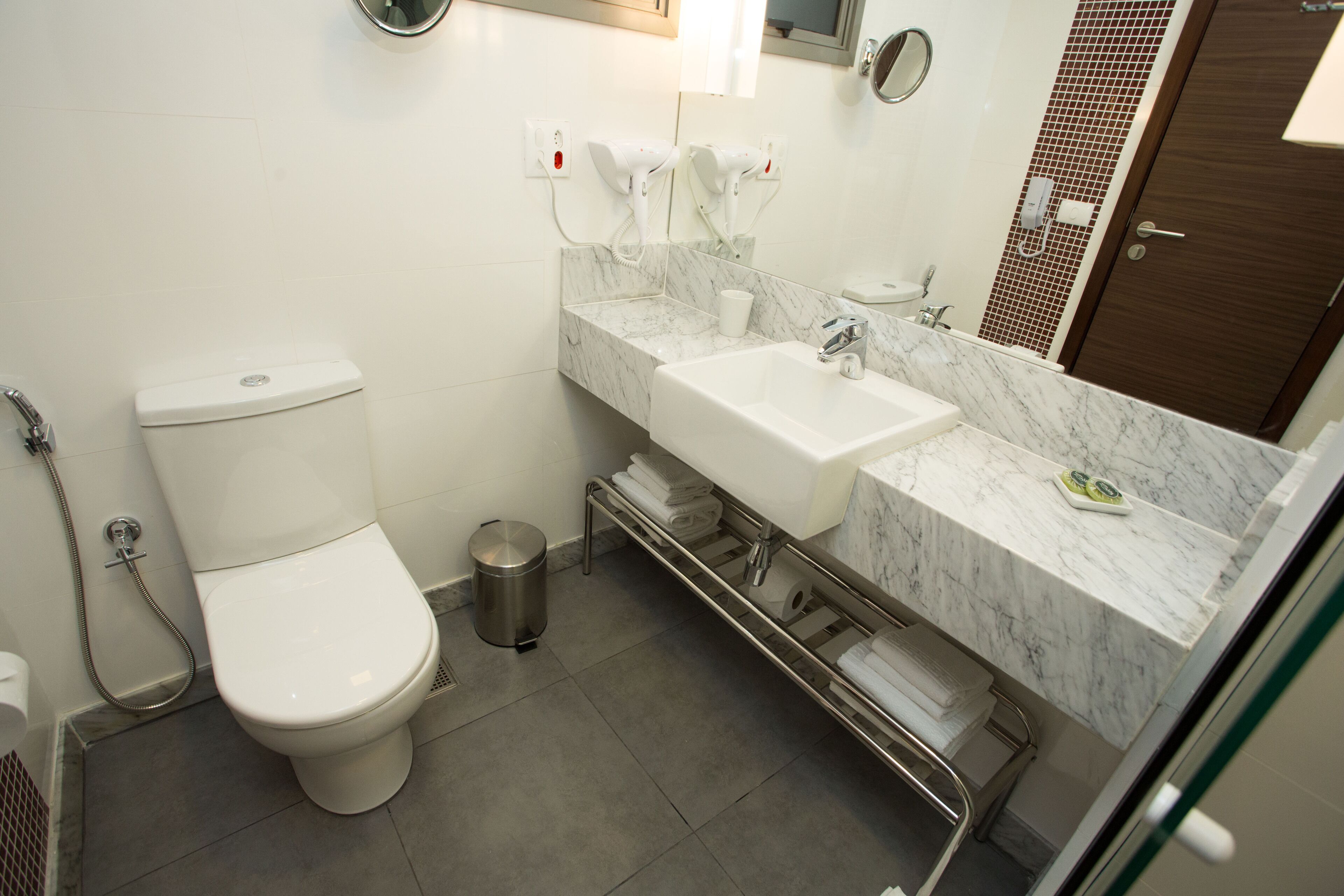 Une salle de bain moderne équipée de toilettes, d’un lavabo et d’une douche.