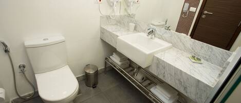 Une salle de bain moderne équipée de toilettes, d’un lavabo et d’une douche.