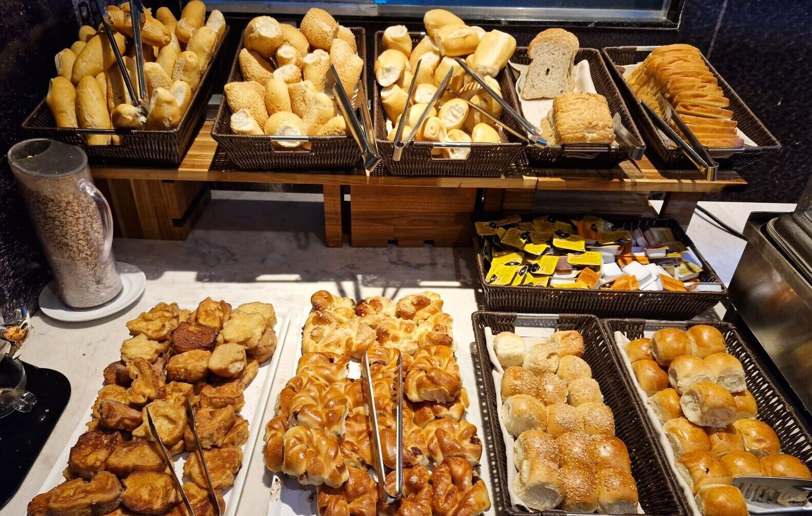A buffet with various breads and pastries.