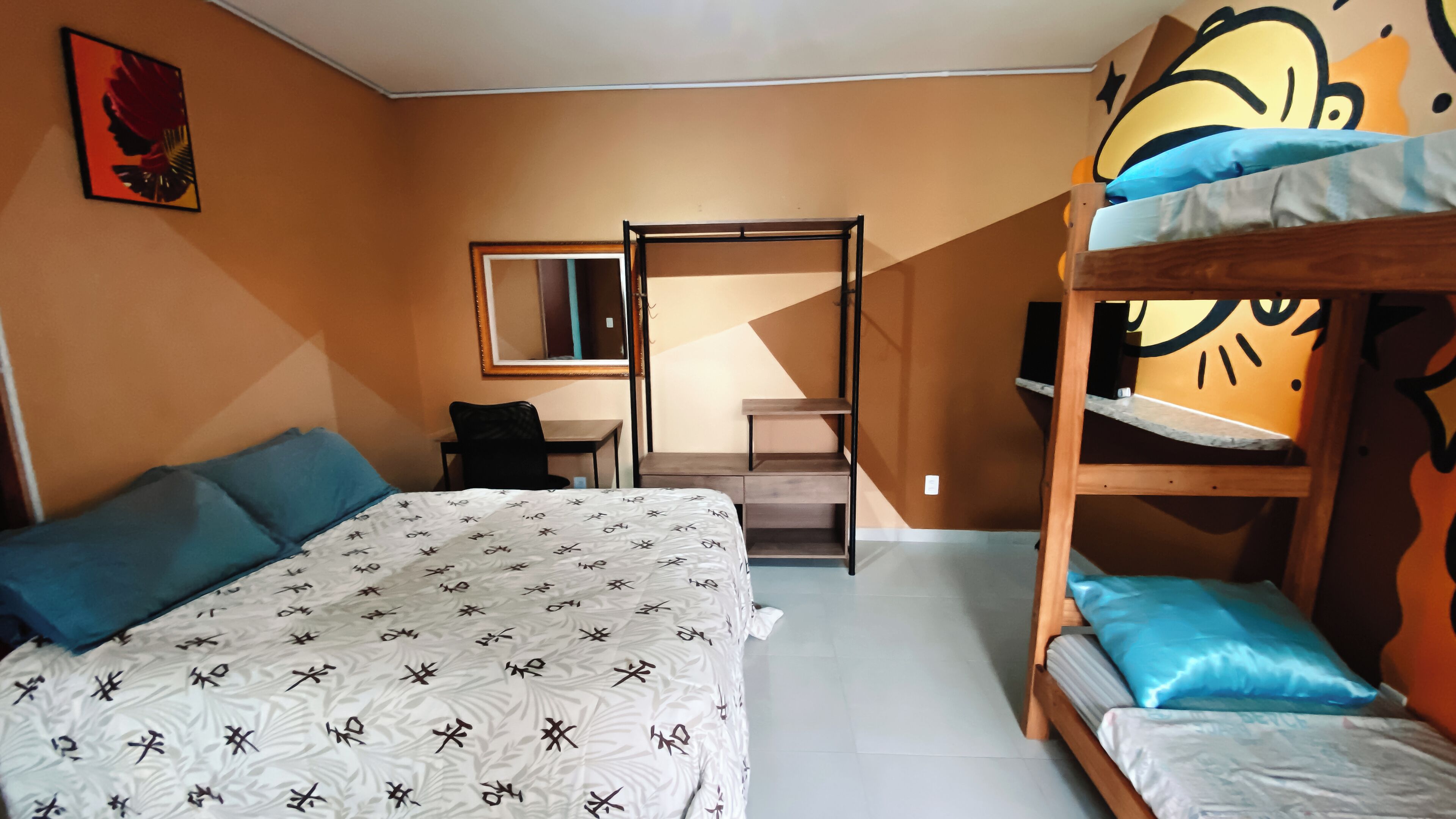 Un dormitorio con una litera, un escritorio y una silla.