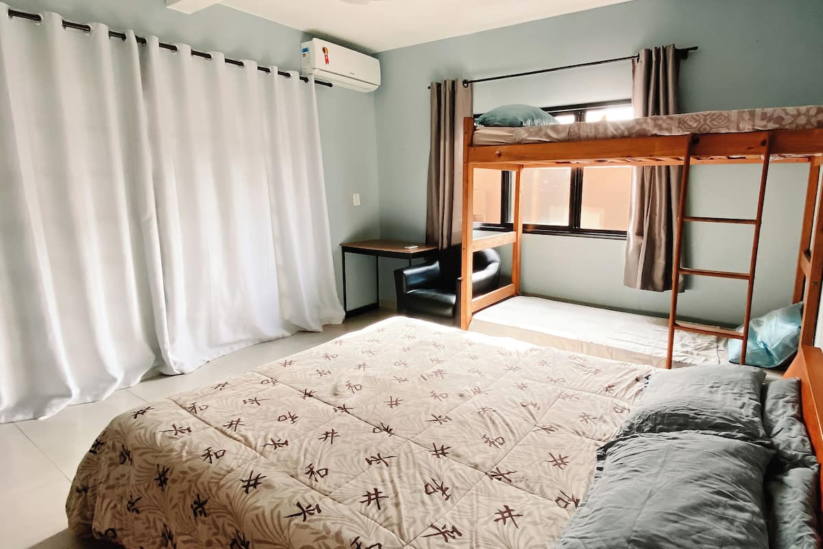 A bedroom with a bunk bed, a desk, and a chair.