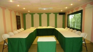 A conference room with a long table, chairs, and a projector screen. - Victoria Guest House (Limbe)