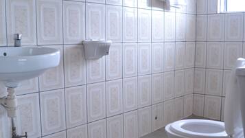 A bathroom with a sink, toilet, and a window.