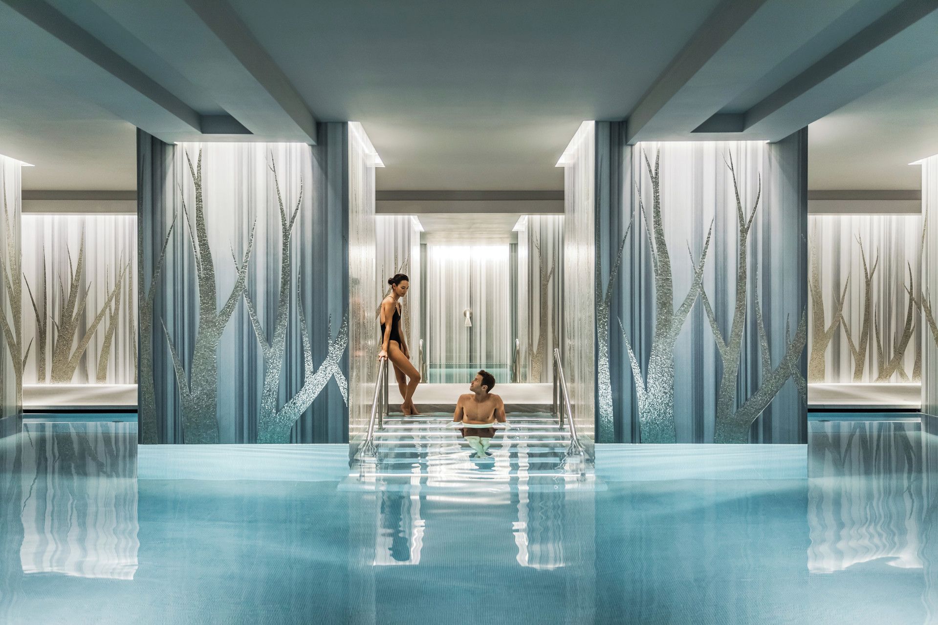 Una piscina techada, sillones reclinables de piscina