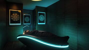 Quarto com poltrona reclinável, quadros decorativos nas paredes e luminária pendente com design curvo.