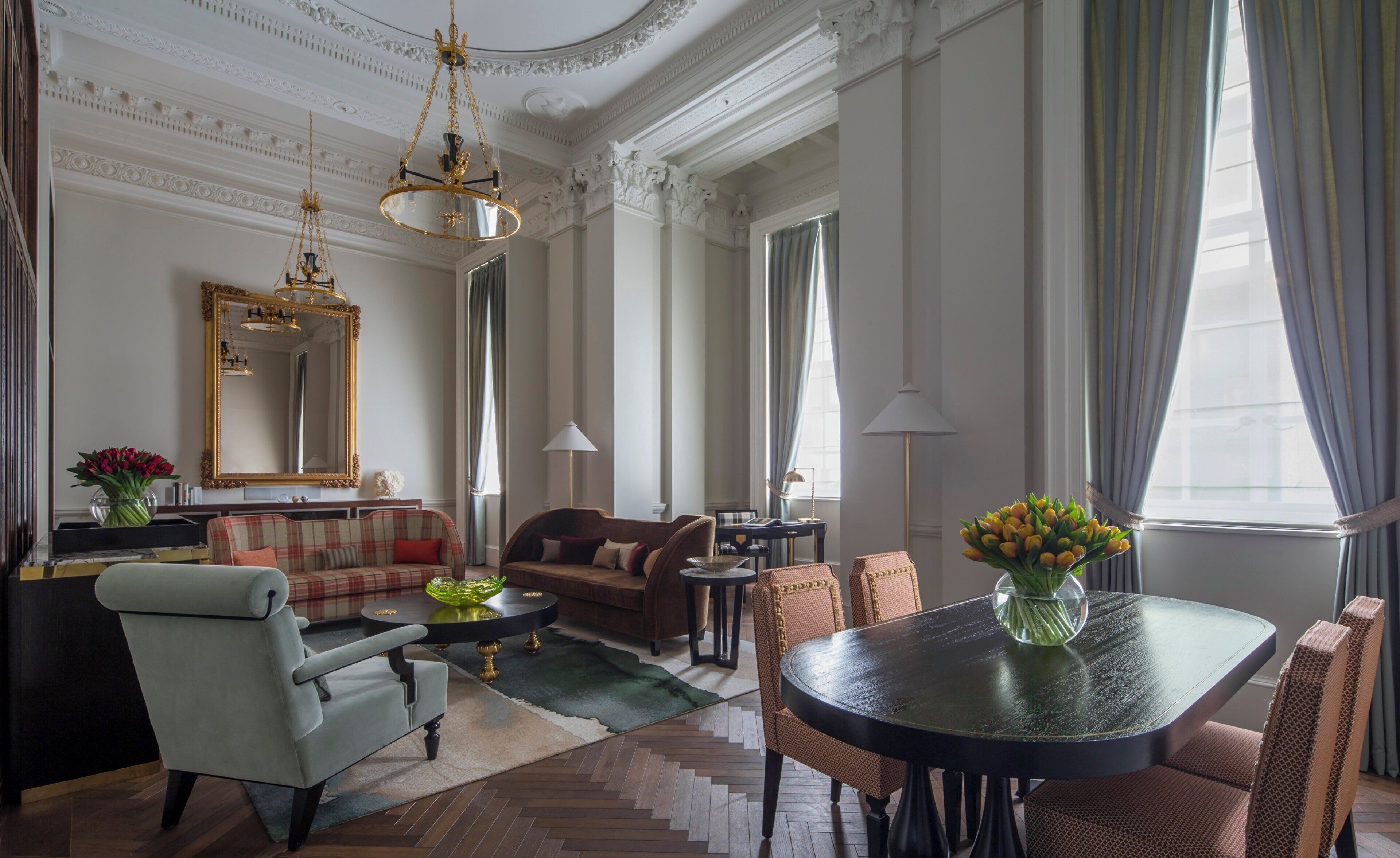 A spacious living room with a large round table, comfortable seating, and elegant decor.
