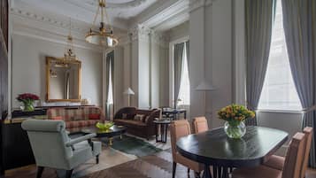 A spacious living room with a large round table, comfortable seating, and elegant decor.
