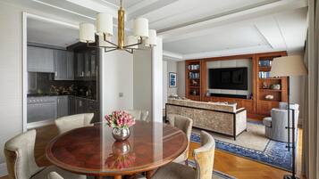 A modern kitchen with dark cabinets, a central island, and a dining area with a round table and chairs.