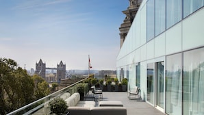 A rooftop terrace with seating, a view of the city, and a flag. - Four Seasons Hotel London at Tower Bridge (London)