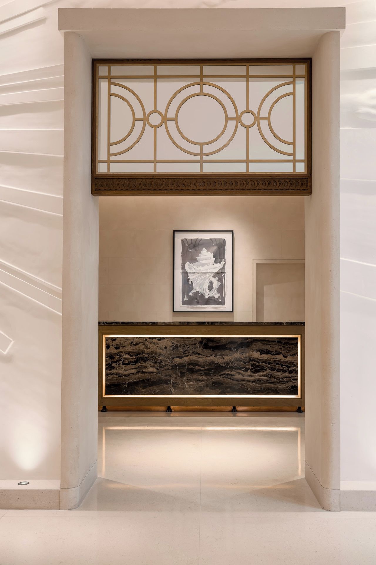 A hallway with a decorative wooden screen, a framed artwork on the wall, and a stone bench.