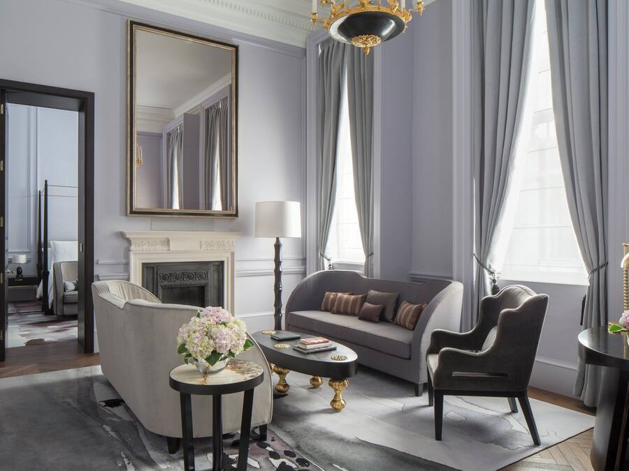 Un salon moderne avec une cheminée, un canapé, une table basse et un lustre.