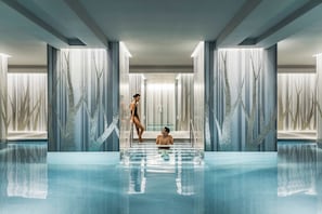 A modern indoor swimming pool with a glass floor, surrounded by walls with vertical tree-like patterns. - Four Seasons Hotel London at Tower Bridge (London)