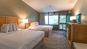 A hotel room with two beds, a desk, a chair, and a large window with a view of trees. - Rough River Dam State Resort Park (Falls of Rough)