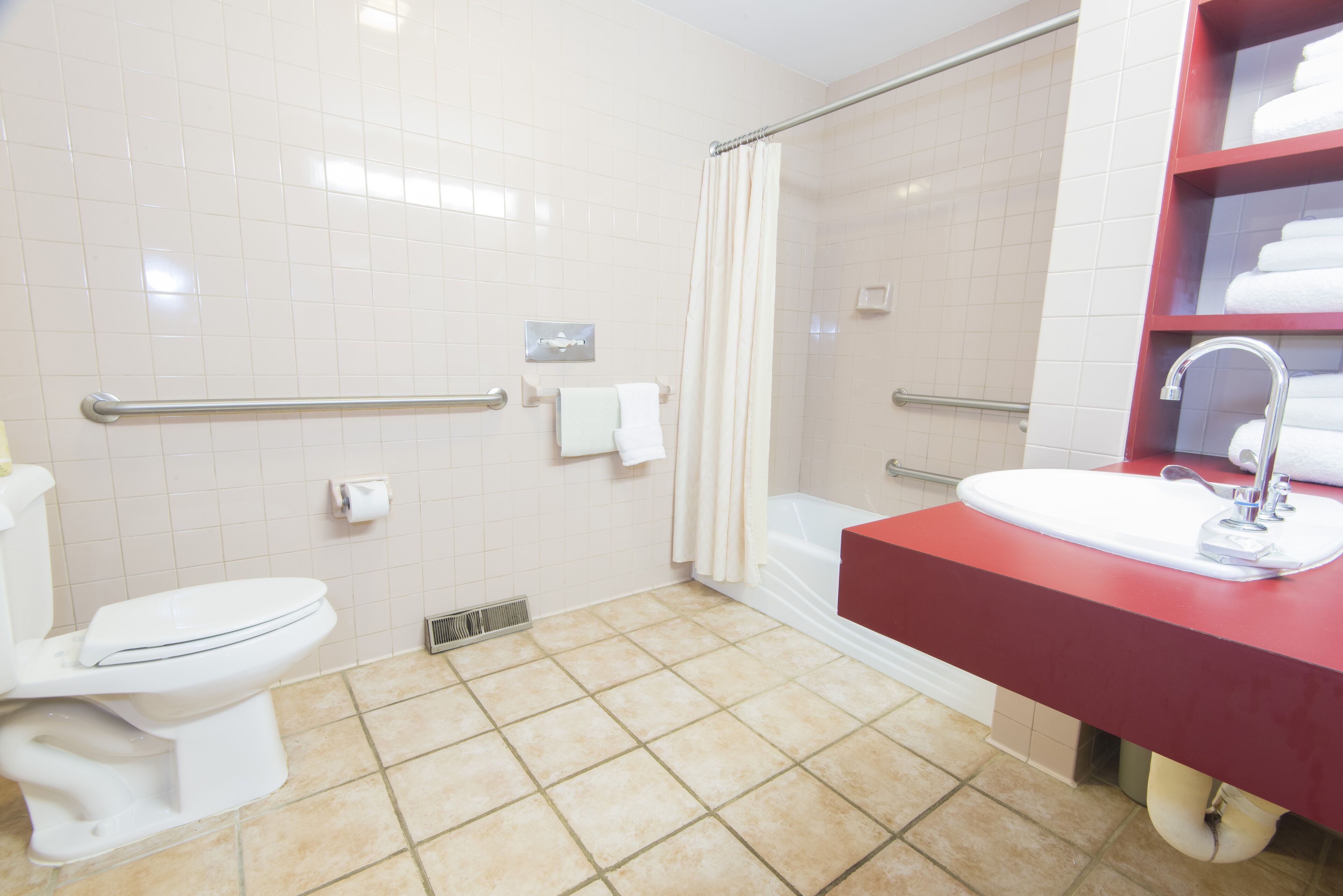 Ein Badezimmer mit Toilette, Waschbecken, Dusche und Handtuchhalter.