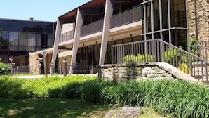A modern building with a stone facade, large windows, and a balcony with metal railings. - Rough River Dam State Resort Park (Falls of Rough)