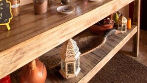 A wooden counter with jars and a chalkboard menu.