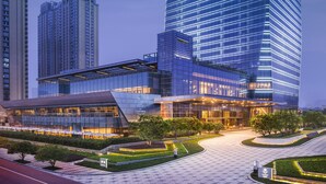 A modern high-rise building with a glass facade and a prominent logo at the top. - Meixi Lake Hotel, A Luxury Collection Hotel, Changsha (Changsha)