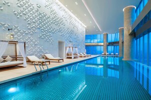 Indoor pool, open 6:00 AM to 11:00 PM, pool loungers, lifeguards on site