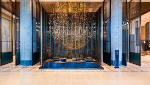 A modern lobby with a central water feature, glass partitions, and a tiled floor. - Meixi Lake Hotel, A Luxury Collection Hotel, Changsha (Changsha)