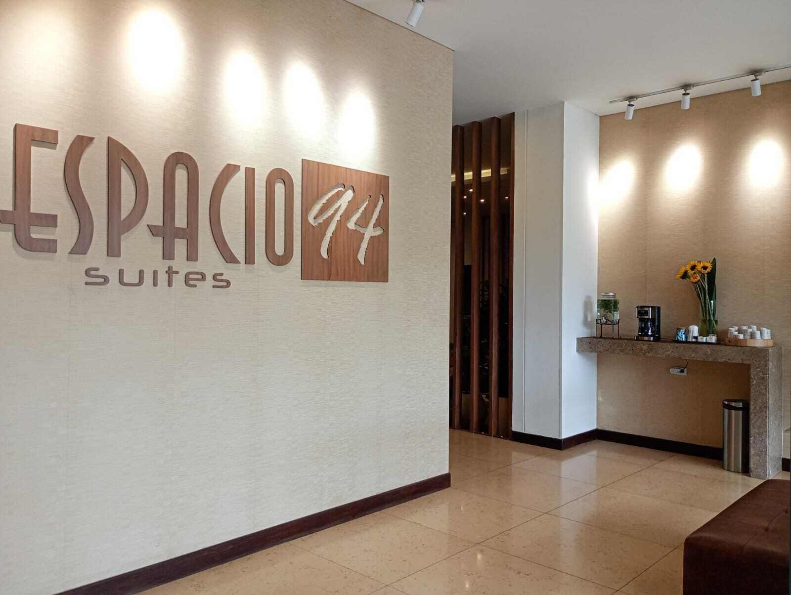 A reception area with a sign reading "ESPACIO 94 Suites".