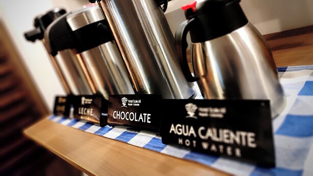 A display of hot water bottles labeled with flavors like chocolate and agua caliente. - Hotel Scala 68 (Bogotá)