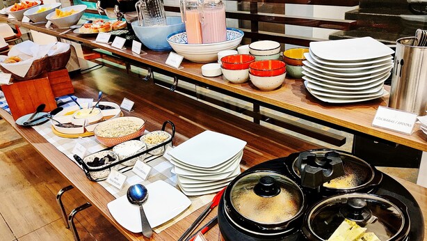 A buffet setup with various food items and utensils. - Hotel Scala 68 (Bogotá)